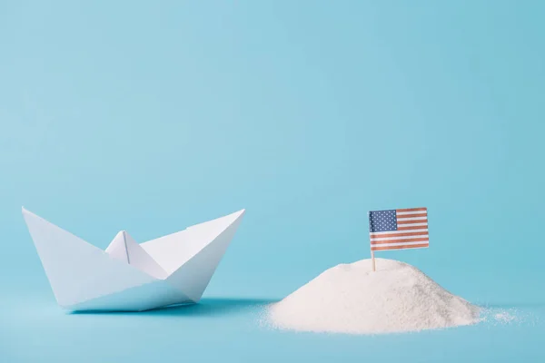 青い背景に白い砂のアメリカ国旗の近くの紙ボート — ストック写真