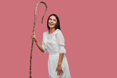 pembe izole ahşap baston tutan gülümseyen kadın 