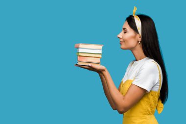 mavi izole kitap tutan kadın yan görünümü 