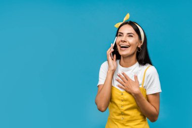 mavi izole akıllı telefonda konuşan mutlu kadın 