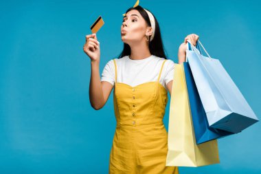 ördek yüzlü genç kadın mavi izole kredi kartı bakıyor 