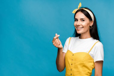 mavi izole el ile kalp gösteren mutlu genç kadın 