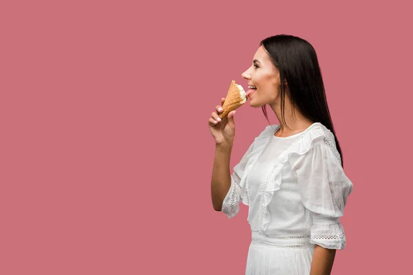侧视图的快乐女人吃美味的冰淇淋孤立在粉红色 — 图库照片