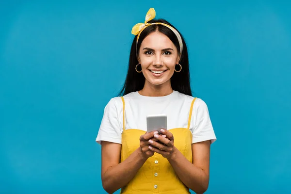 Mujer Alegre Sosteniendo Teléfono Inteligente Mientras Mira Cámara Aislada Azul — Foto de Stock