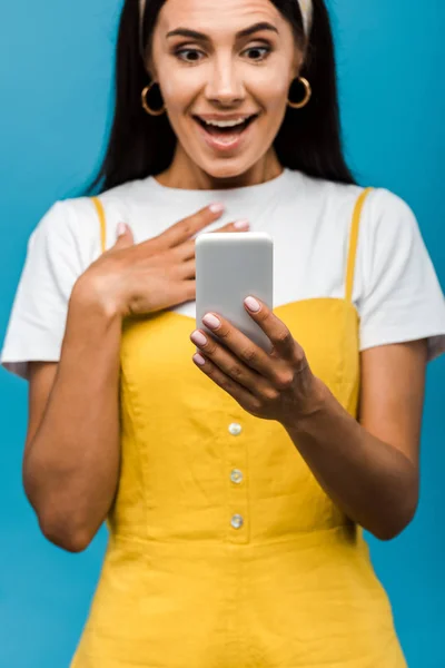 Enfoque Selectivo Chica Sorprendida Mirando Teléfono Inteligente Aislado Azul — Foto de Stock