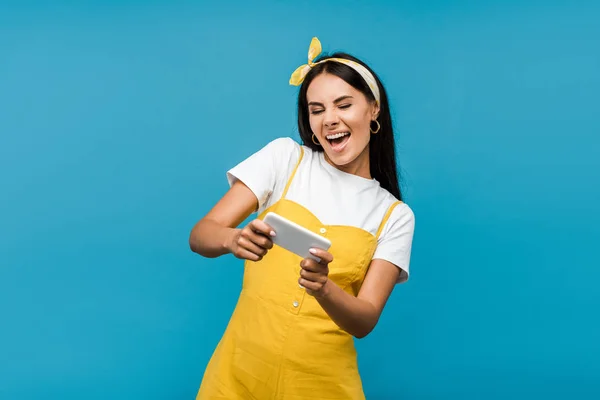 Gelukkige Vrouw Gele Jurk Met Behulp Van Smartphone Geïsoleerd Blauw — Stockfoto