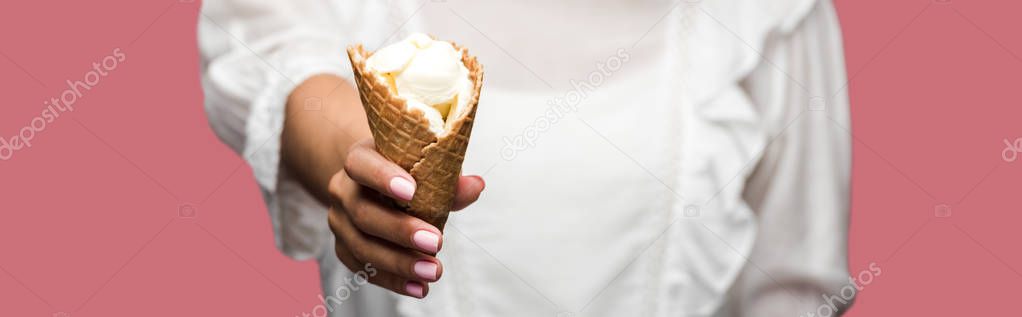 panoramic shot of woman in dress holding tasty ice cream cone isolated on pink 