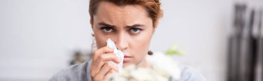 panoramic shot of sick woman with pollen allergy holding tissue near flowers  clipart
