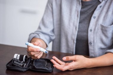 elinde kan lancet tutan kadın kırpılmış görünümü 
