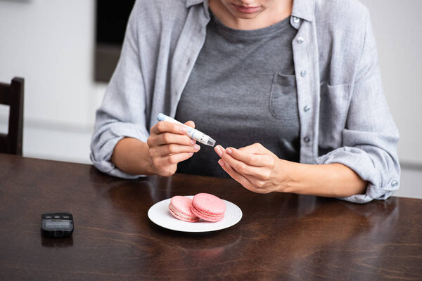 cropped view of woman making test while holding blood lancet 