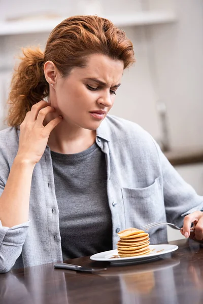 Sick Woman Scratching Neck While Holding Fork Pancakes — Stock Photo, Image
