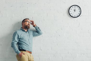 gömlek ve gözlük içinde dalgın işadamı ofis uzağa bakıyor 