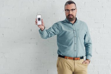 Kiev, Ukrayna - 27 Ağustos 2019: uber logolu akıllı telefonu cepte eliyle tutan yakışıklı işadamı