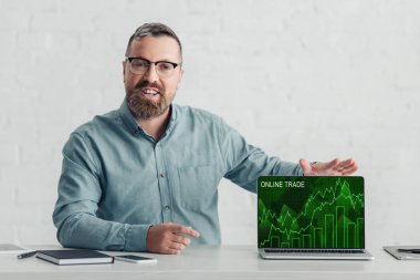 online ticaret web sitesi ile dizüstü bilgisayar tutan gömlek yakışıklı işadamı 