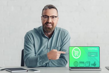alışveriş web sitesi ile dizüstü bilgisayarda parmak ile işaret gömlek yakışıklı işadamı 