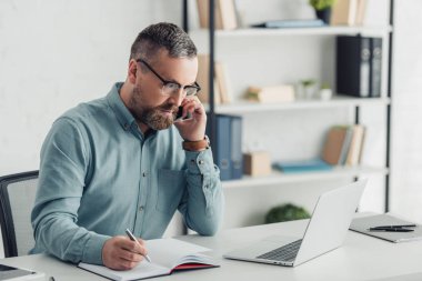 handsome businessman in shirt and glasses talking on smartphone 