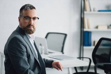 resmi giyim ve gözlük yakışıklı işadamı ofiste kamera bakarak 