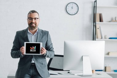 Kiev, Ukrayna - 27 Ağustos 2019: deezer logolu dijital tablet tutan resmi giyim yakışıklı işadamı