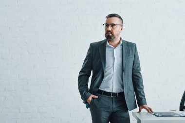 resmi giyim ve gözlük yakışıklı işadamı uzağa bakıyor 