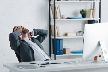 resmi giyimli işadamının panoramik fotoğrafı çapraz kollarla otururken 