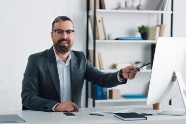 resmi giyim kalem tutan yakışıklı işadamı ve kamera bakıyor 