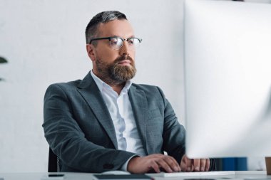bilgisayar kullanarak resmi giyim ve gözlük yakışıklı işadamı 