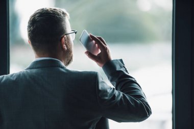 resmi giyim akıllı telefon tutan adam geri görünümü 