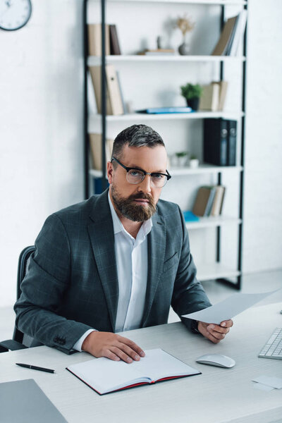 handsome businessman in formal wear and glasses doing paperwork 