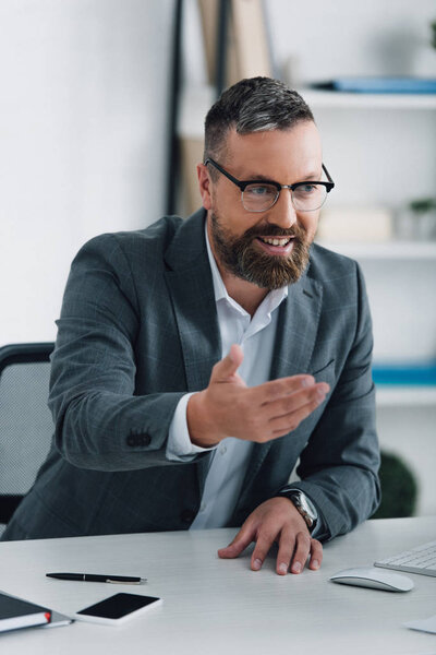 handsome businessman in formal wear smiling and looking away 