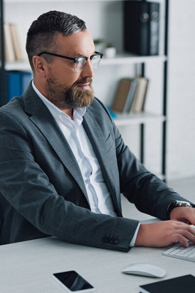 handsome businessman in formal wear and glasses using computer 