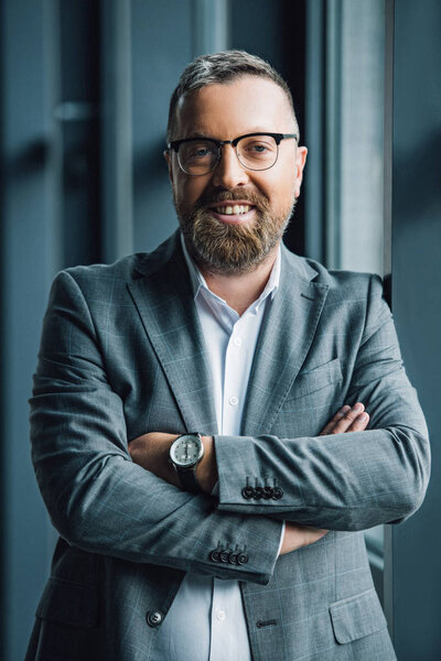 handsome businessman in formal wear and glasses looking at camera 