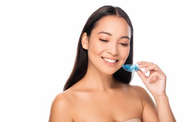 beyaz izole ağızlık tutan gülümseyen asyalı kadın