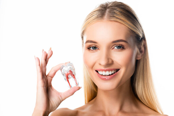 smiling woman with white teeth holding tooth model isolated on white