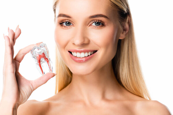 naked smiling woman with white teeth holding tooth model isolated on white