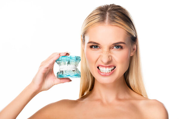 naked woman showing teeth and holding jaw model isolated on white