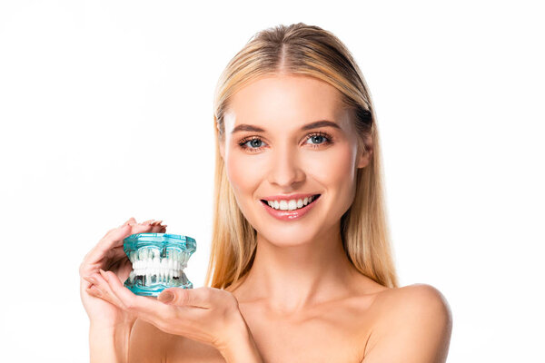 naked smiling woman with white teeth holding jaw model isolated on white