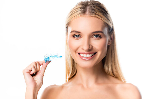 naked happy blonde woman with white teeth holding mouth guard isolated on white