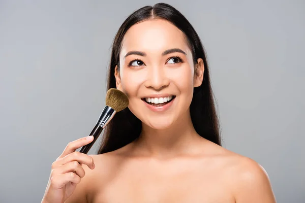 灰色で隔離された化粧品ブラシで笑顔の裸のアジアの女性 — ストック写真