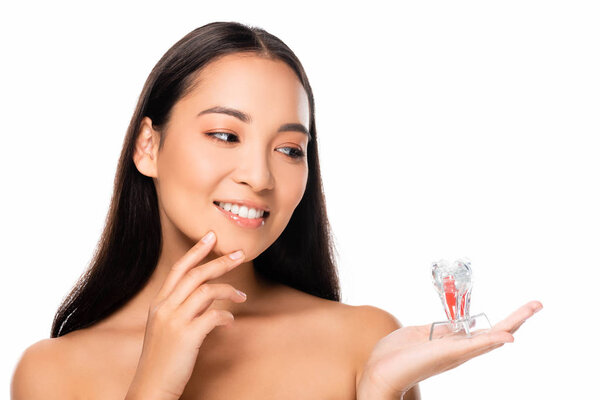 happy naked asian woman looking at tooth model isolated on white