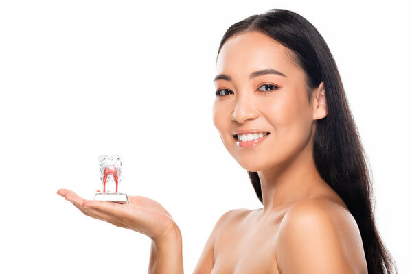 cheerful naked asian woman holding tooth model isolated on white