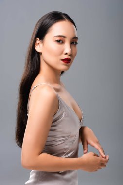 gri izole poz kırmızı dudaklar ile saden elbise güzel gülümseyen asyalı kadın yan görünümü