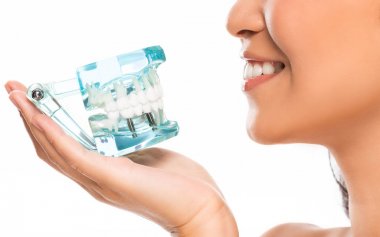 beyaz izole çene modeli tutan gülümseyen kadın kırpılmış görünümü