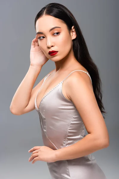 灰色に隔離された赤い唇を持つサティンドレスの美しいアジアの女性 — ストック写真