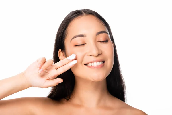 赤裸裸的美丽的亚洲女人与化妆品霜的手指和闭上的眼睛孤立在白色 — 图库照片