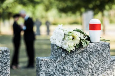 mezar taşına beyaz çiçek ve mezarlık vazosu buketseçici odak