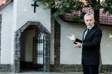 kilise yakınında gesturing takım elbise yakışıklı yaşlı adam 