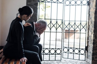 mezarlıkta sinirli üst düzey adam yakınında bankta oturan güzel kadın 
