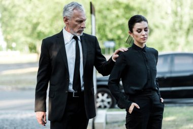 sakallı adam ceplerinde elleri ile çekici kadının eline dokunmadan 
