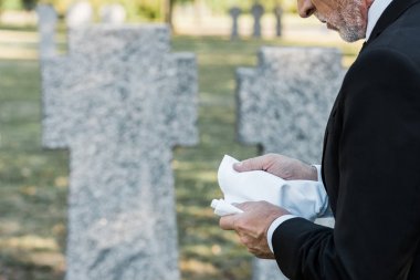 mezarlıkta elinde mendil tutan kıdemli adam kırpılmış görünümü 