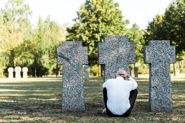 Tillbaka Syn Mannen Med Grått Hår Sitter Nära Gravstenar Kyrkogården — Stockfoto